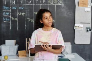 woman in pink and yellow crew neck t shirt holding brown notebook